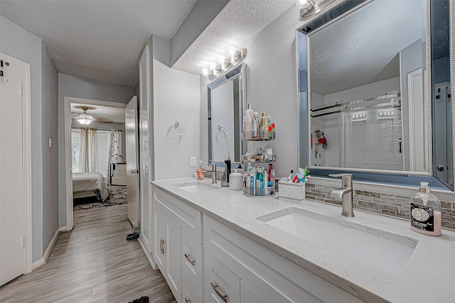 bathroom featuring tasteful backsplash, vanity, ceiling fan, hardwood / wood-style floors, and a shower with shower door