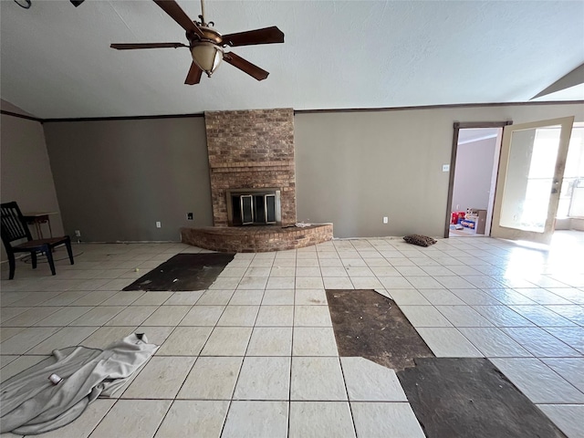 unfurnished living room with a brick fireplace, ceiling fan, lofted ceiling, and light tile patterned flooring