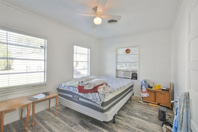 bedroom featuring ceiling fan, cooling unit, dark hardwood / wood-style flooring, and ornamental molding