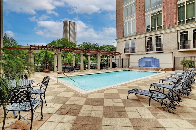 view of pool with pool water feature, a pergola, and a patio