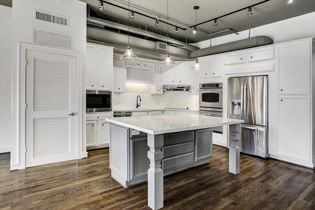 kitchen with white cabinetry, a center island, decorative light fixtures, and appliances with stainless steel finishes