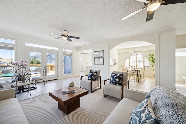 living room with plenty of natural light, a textured ceiling, and light wood-type flooring