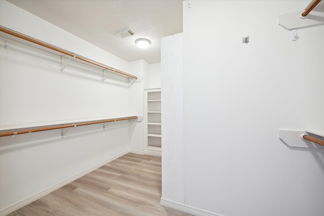 spacious closet with light hardwood / wood-style floors