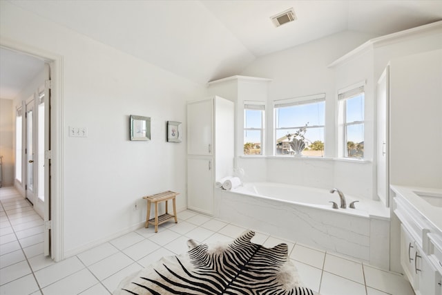 bathroom with tile patterned floors, tiled bath, and vaulted ceiling