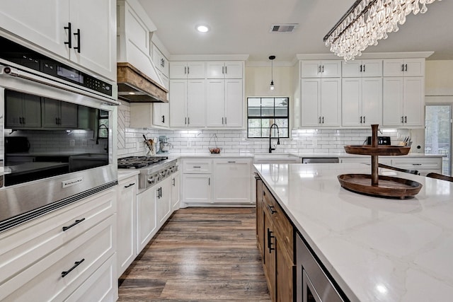 kitchen featuring dark wood-type flooring, white cabinets, hanging light fixtures, a notable chandelier, and stainless steel appliances