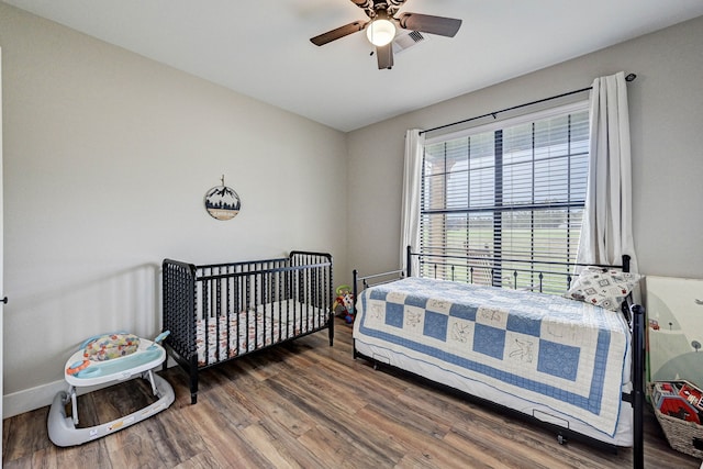 bedroom with ceiling fan and dark hardwood / wood-style floors