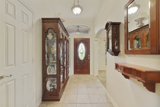 foyer entrance featuring ornamental molding and light tile patterned floors