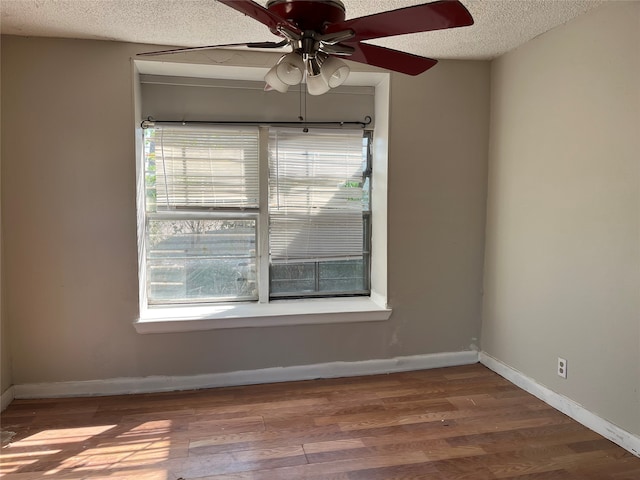 empty room with ceiling fan, a textured ceiling, and hardwood / wood-style flooring