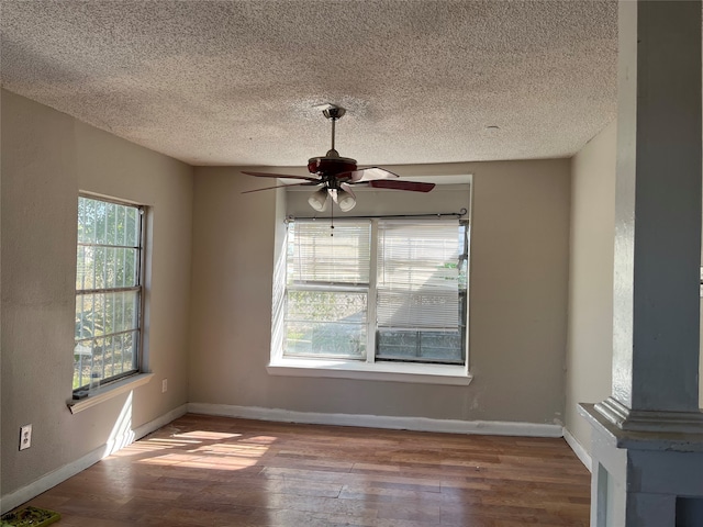 spare room featuring ceiling fan, hardwood / wood-style floors, a healthy amount of sunlight, and a textured ceiling