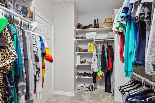 walk in closet featuring light colored carpet