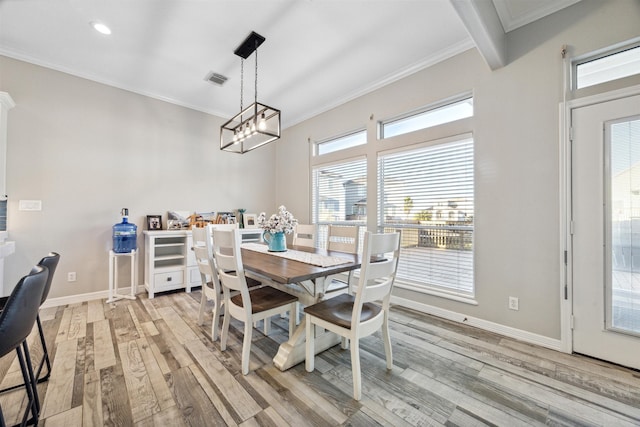 dining area featuring a notable chandelier, ornamental molding, and light hardwood / wood-style flooring