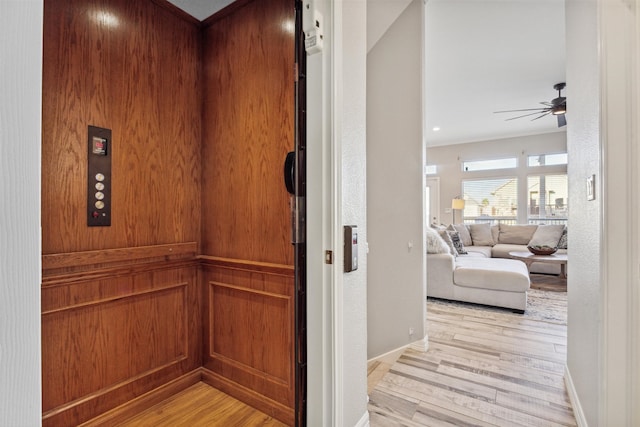 hall with elevator and light hardwood / wood-style floors