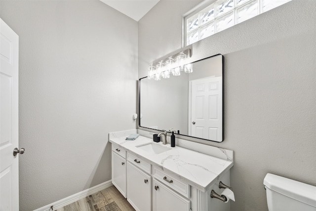 bathroom with vanity, toilet, and wood-type flooring