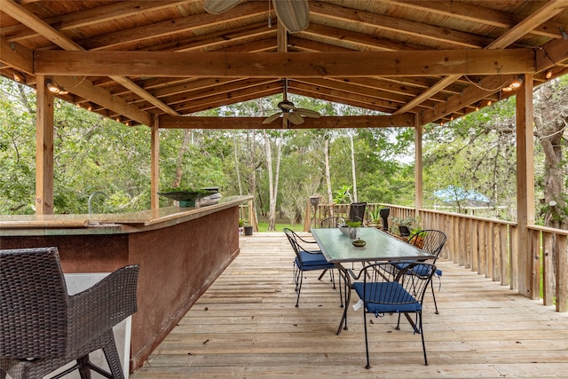 deck with a bar and ceiling fan