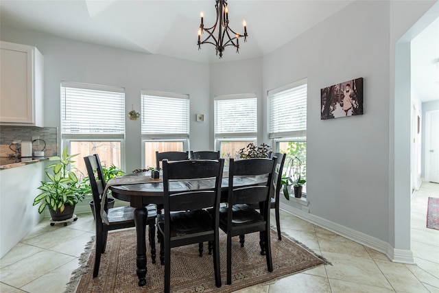 tiled dining room featuring lofted ceiling and a chandelier