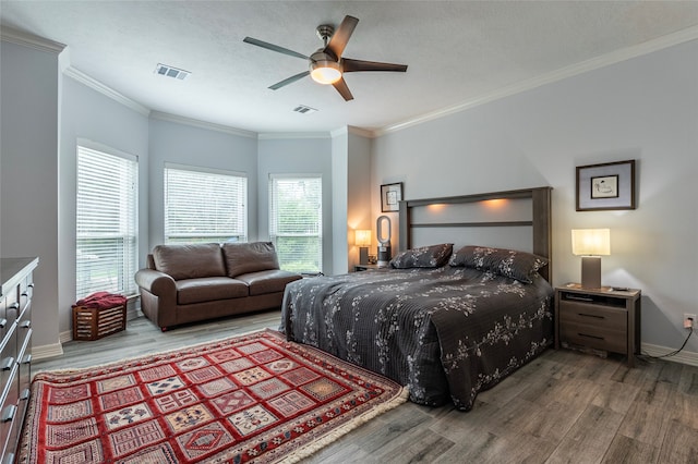 bedroom with hardwood / wood-style flooring, ceiling fan, crown molding, and a textured ceiling