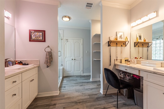 bathroom featuring hardwood / wood-style floors, vanity, an enclosed shower, and ornamental molding