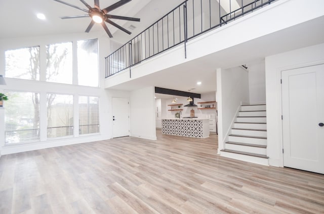 18037 Bal Harbour Dr, Nassau Bay, TX 77058 - unfurnished living room with a wealth of natural light, stairs, light wood-style floors, and a ceiling fan
