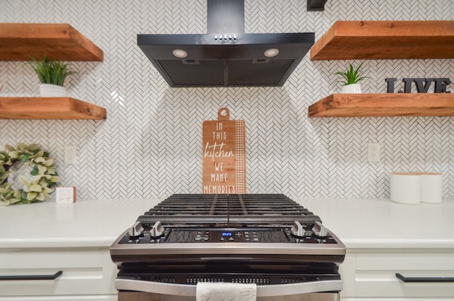 kitchen with exhaust hood, white cabinetry, and stainless steel gas range