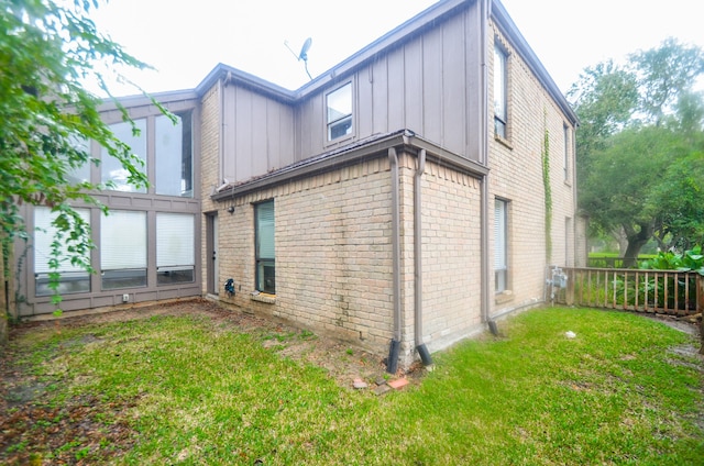 rear view of property featuring a lawn