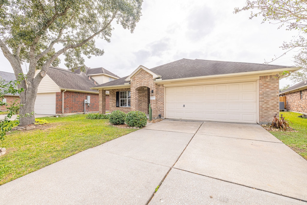 single story home featuring a front yard and a garage