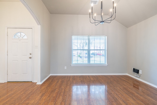 entrance foyer with vaulted ceiling, dark hardwood / wood-style floors, and an inviting chandelier