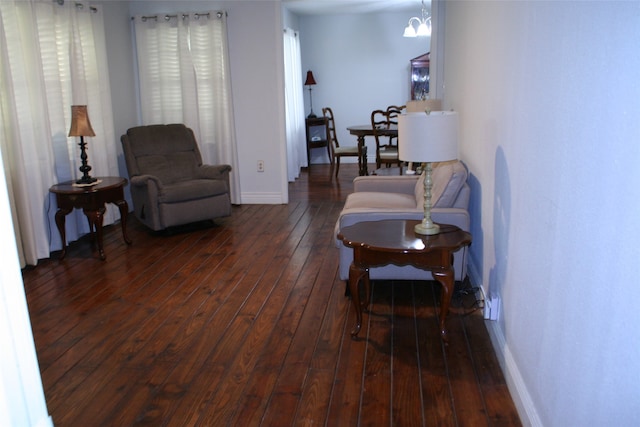 living room featuring dark hardwood / wood-style flooring and an inviting chandelier