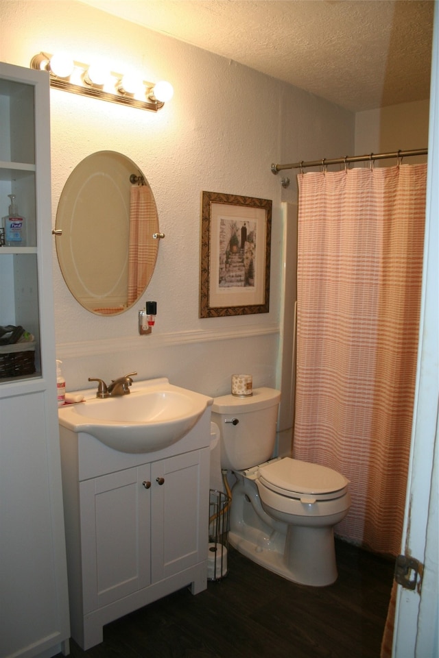 bathroom with a textured ceiling, toilet, hardwood / wood-style flooring, vanity, and a shower with shower curtain