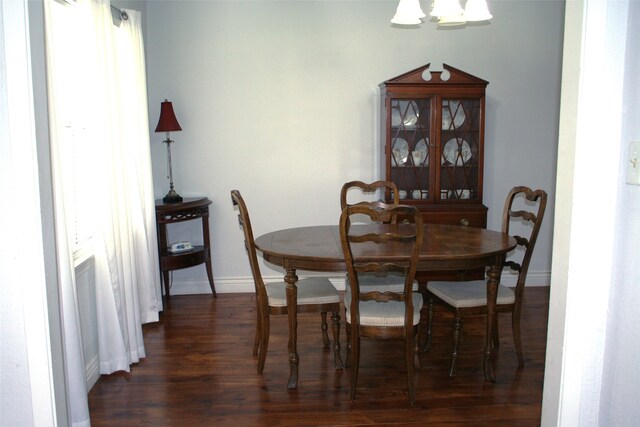 dining area with a chandelier and dark hardwood / wood-style flooring