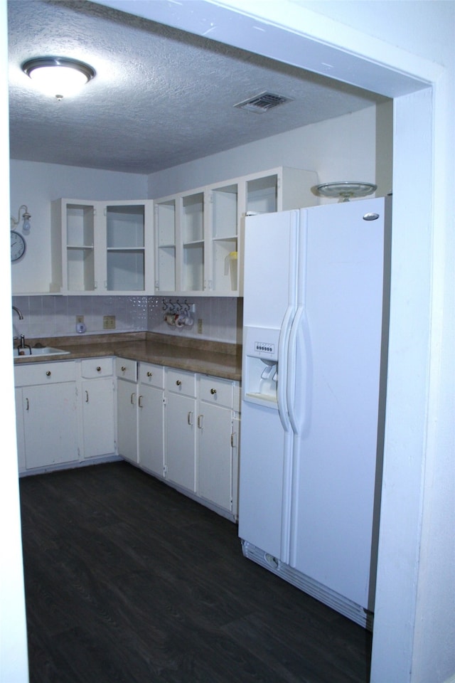 kitchen featuring white fridge with ice dispenser, white cabinets, dark wood-type flooring, and sink