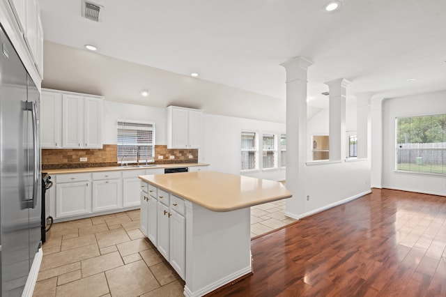 kitchen with a center island, a healthy amount of sunlight, white cabinetry, and light hardwood / wood-style flooring