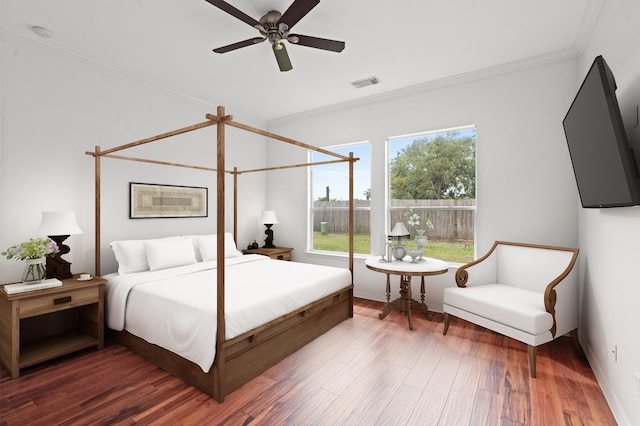 bedroom with ornamental molding, ceiling fan, and dark wood-type flooring