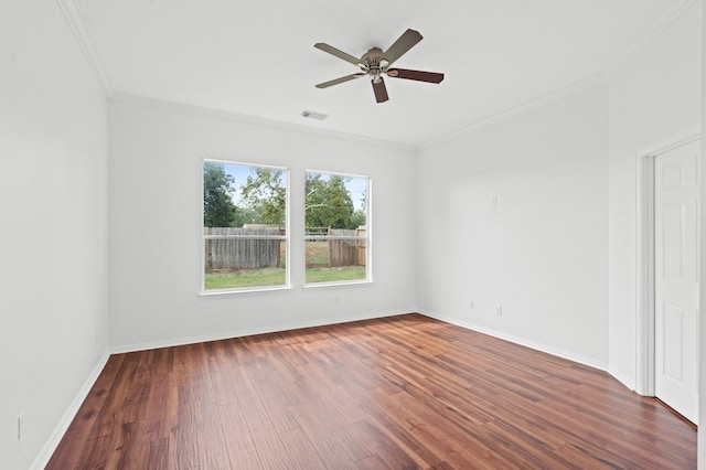 empty room with ornamental molding, ceiling fan, and dark wood-type flooring