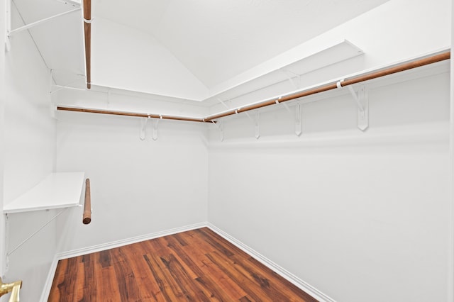 walk in closet with dark hardwood / wood-style flooring and vaulted ceiling