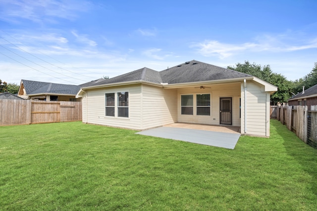 rear view of house featuring ceiling fan, a yard, and a patio