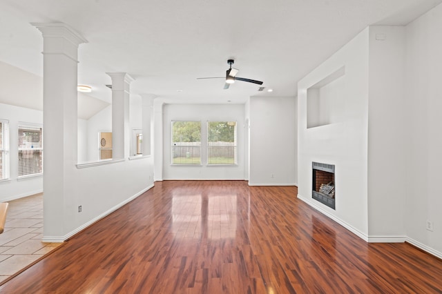 unfurnished living room with ceiling fan, wood-type flooring, and decorative columns