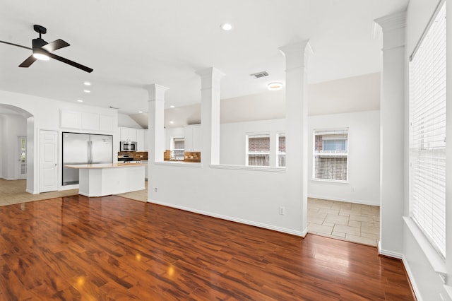 unfurnished living room featuring hardwood / wood-style floors, decorative columns, and ceiling fan