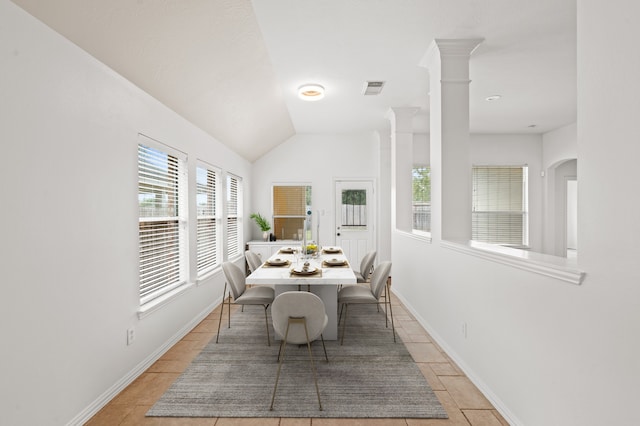 dining room with ornate columns and lofted ceiling