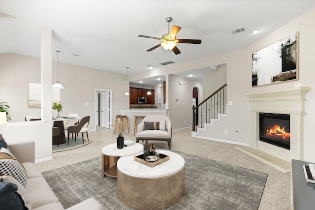 carpeted living room with ceiling fan