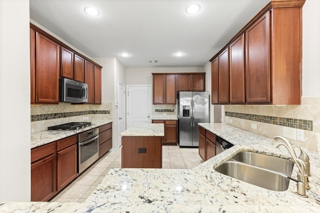 kitchen featuring sink, stainless steel appliances, light stone counters, backsplash, and light tile patterned floors