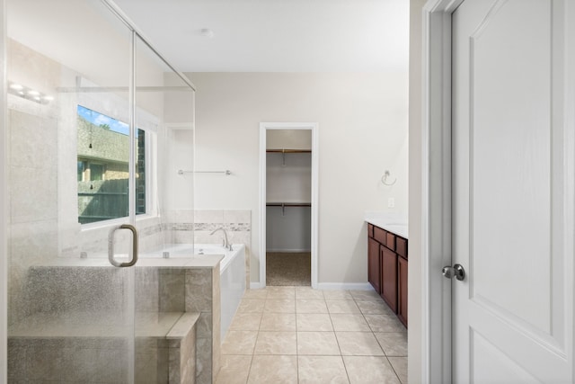 bathroom featuring plus walk in shower, vanity, and tile patterned floors