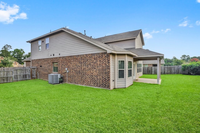 back of house with a lawn, a patio area, and central air condition unit