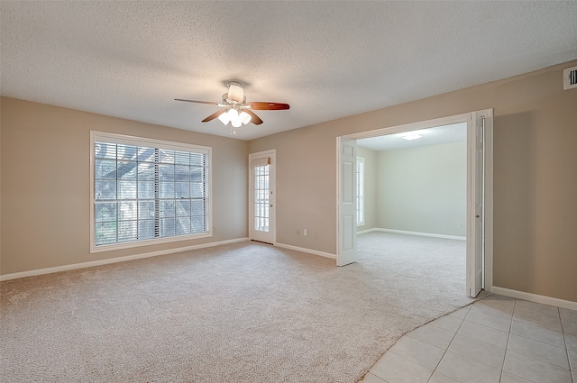 unfurnished room with a textured ceiling, light colored carpet, and ceiling fan