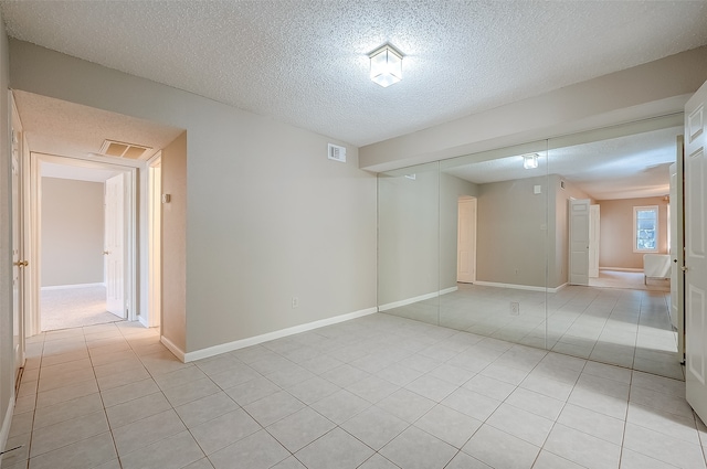 tiled spare room with a textured ceiling