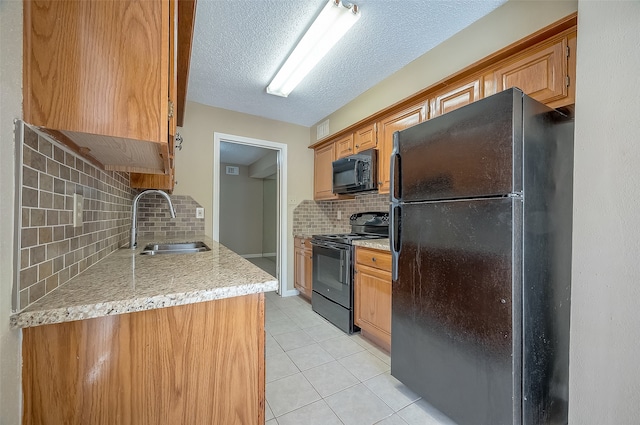 kitchen with black appliances, sink, light tile patterned floors, a textured ceiling, and tasteful backsplash