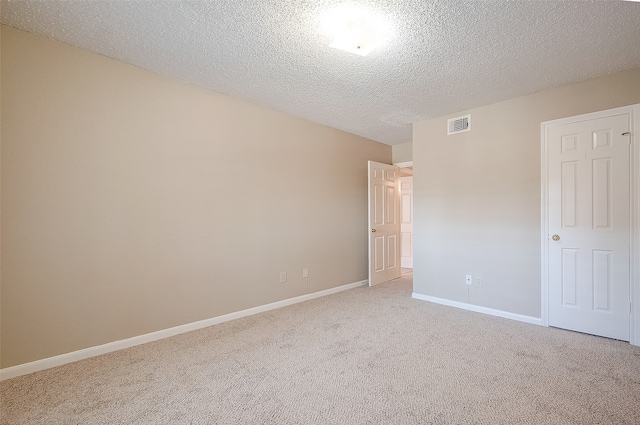 carpeted spare room featuring a textured ceiling