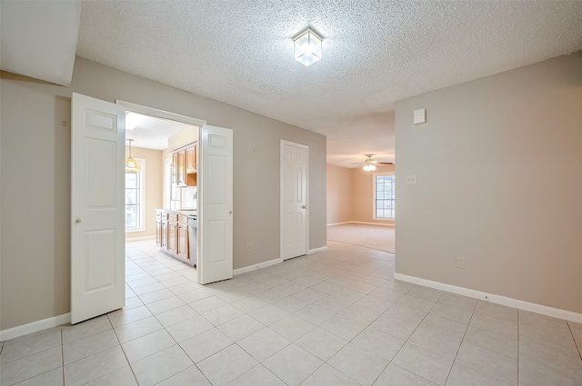 tiled spare room featuring ceiling fan and a textured ceiling