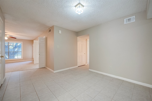 unfurnished room featuring ceiling fan, light tile patterned floors, and a textured ceiling