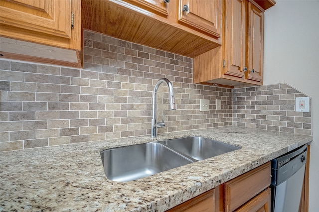 kitchen featuring decorative backsplash, stainless steel dishwasher, light stone countertops, and sink