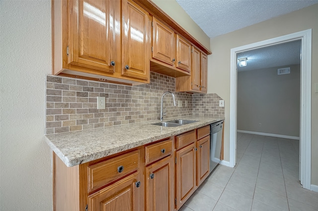 kitchen with tasteful backsplash, stainless steel dishwasher, a textured ceiling, sink, and light tile patterned flooring